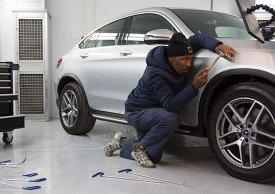 Mobile dent repair technician at work